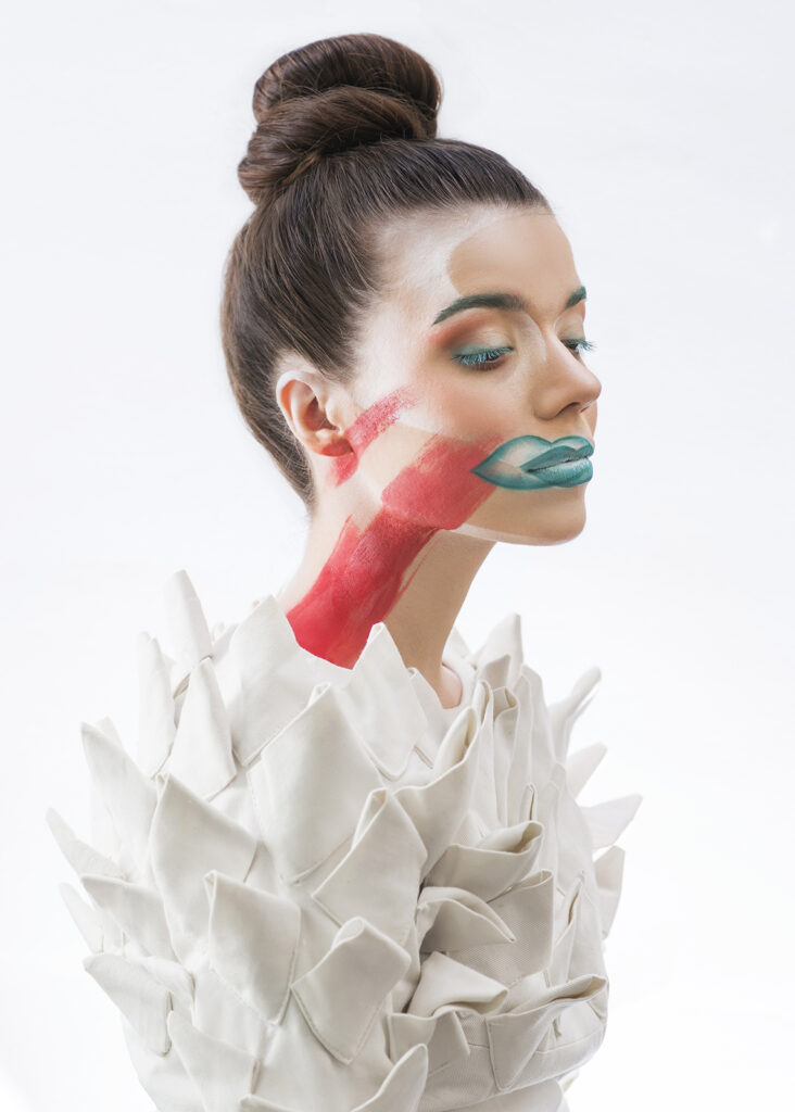 portret beauty kobiety z kreatywnym makijażem, białe tło studyjne