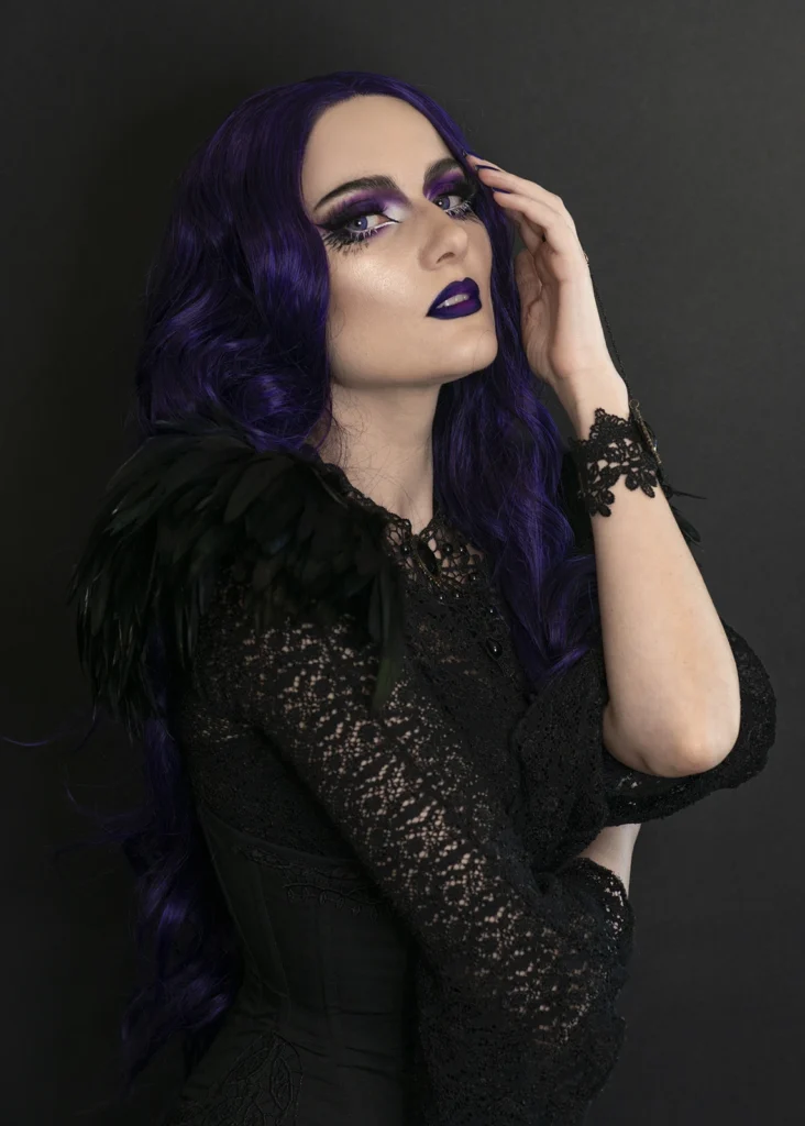 portret kobiety z fioletowymi włosami, ciemne tło, styl beauty