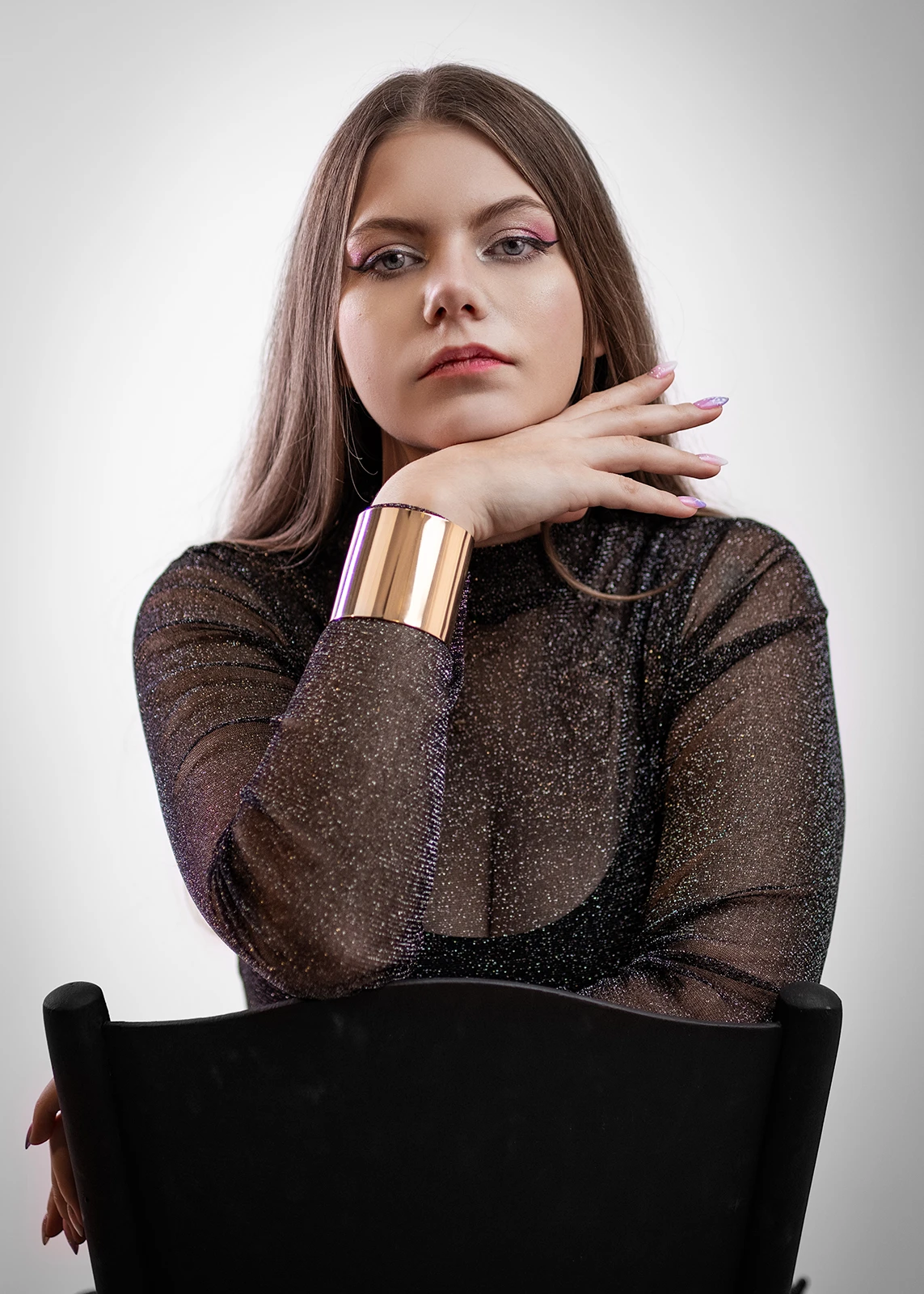 Portret kobiecy w studio w Częstochowie – kobieta w czarnym golfie z dłonią przy twarzy.