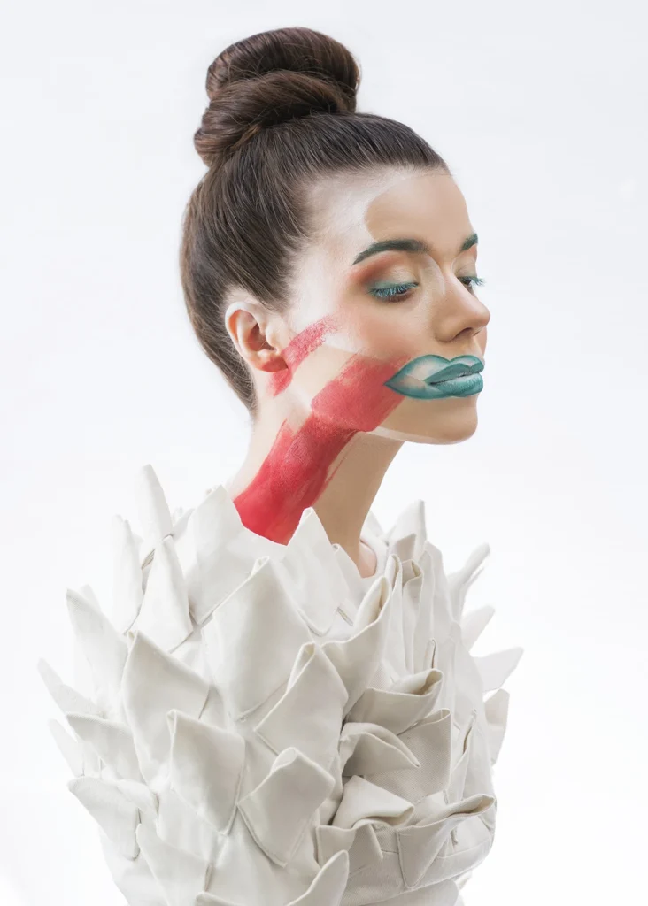 Portret beauty na jasnym tle, kobieta z upiętymi włosami i artystycznym makijażem