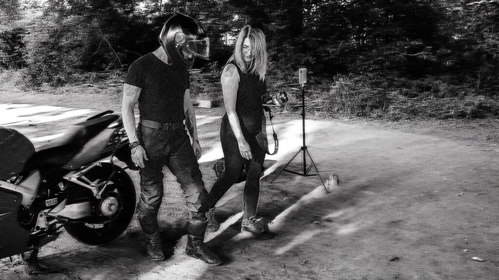 Mężczyzna podczas backstage’u sesji motocyklowej prowadzony przez fotografa przed obiektywem.